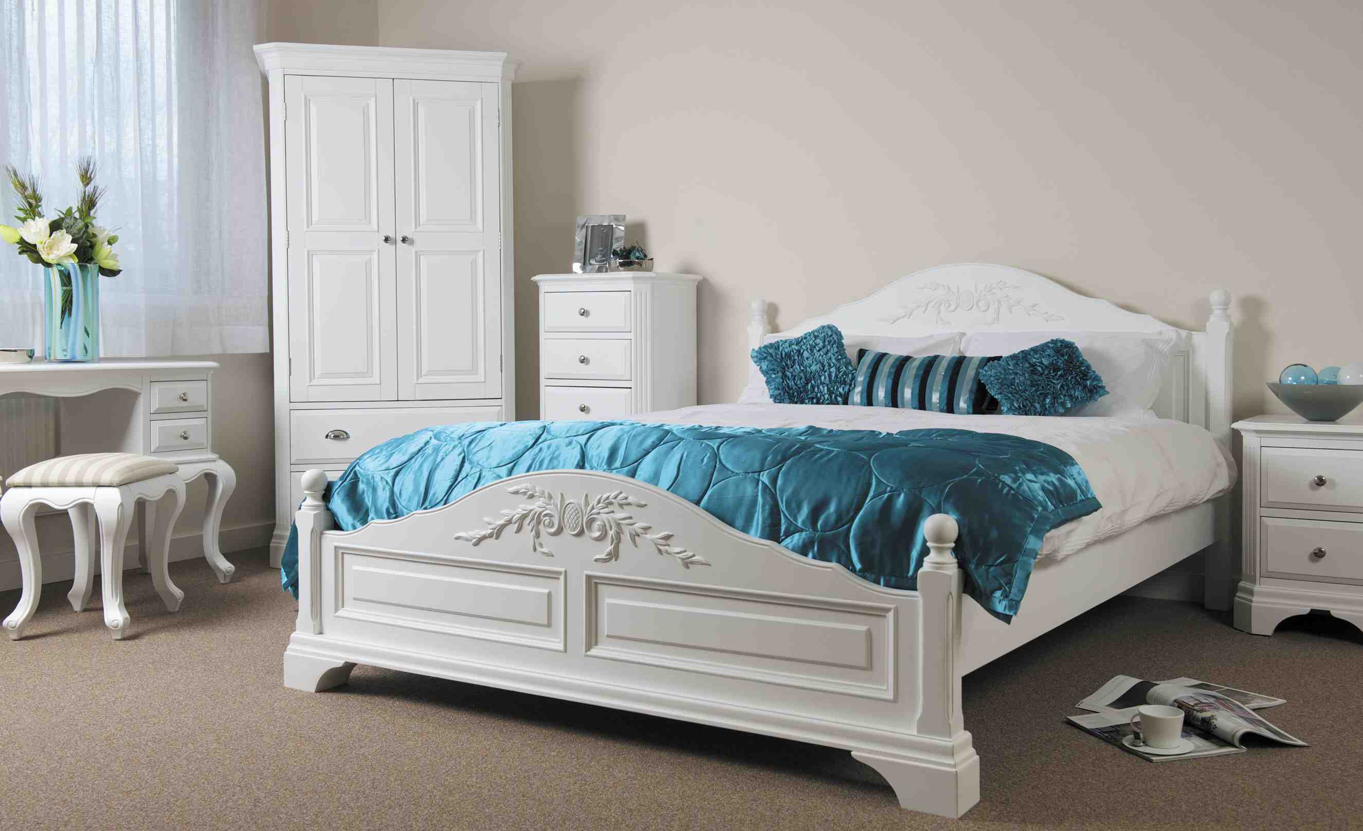 Белая кровать с бирюзовыми подушками