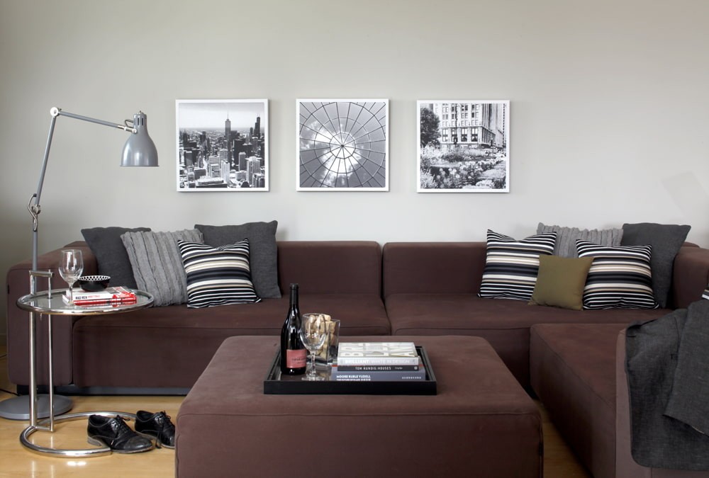Три фотографии в тонких рамках над диваном