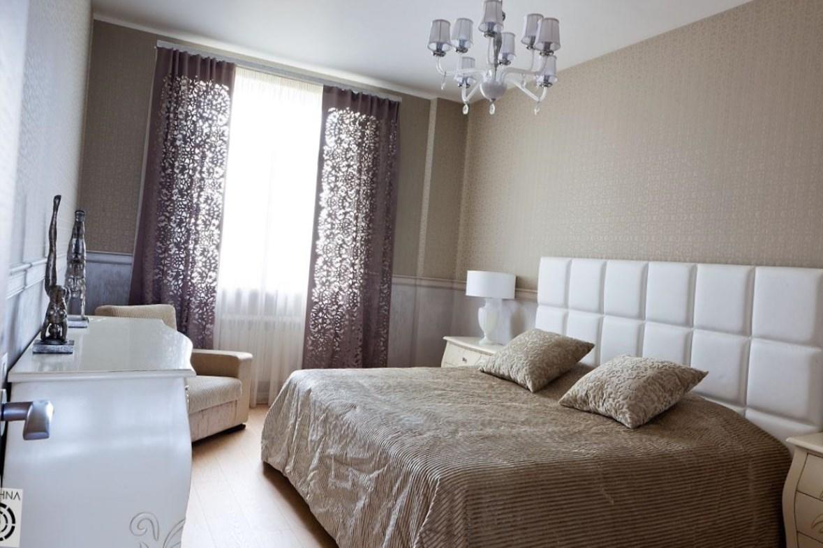 Белую кровать в интерьере спальни можно дополнить темными покрывалами