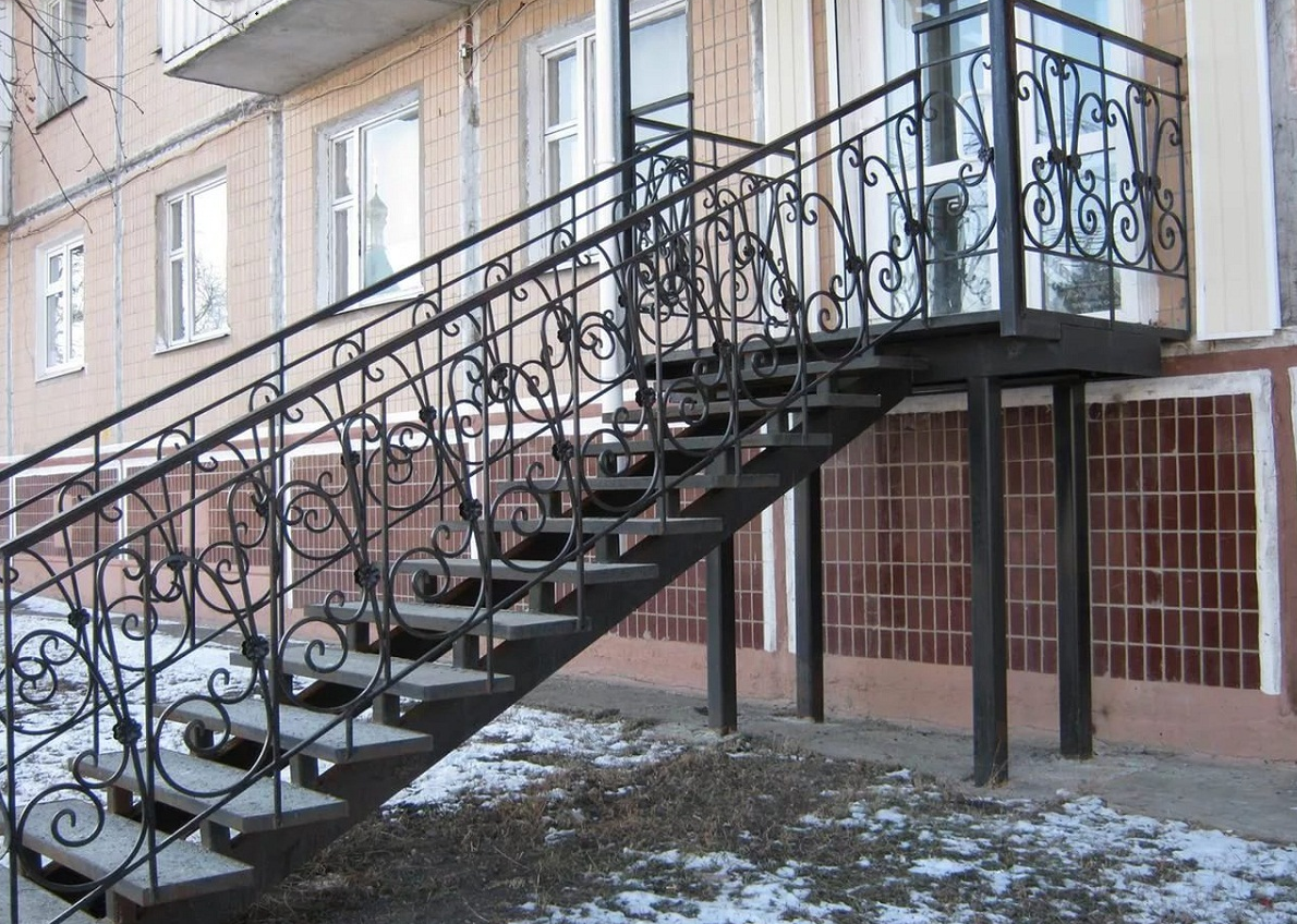 Улучшить эстетические качества уличной металлической лестницы можно с помощью перил с кованными элементами 
