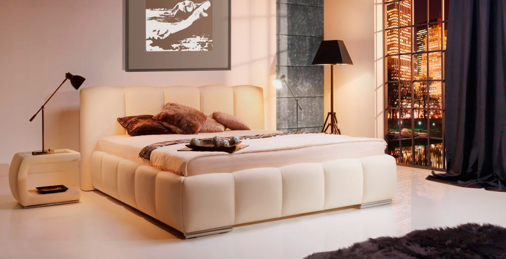 Мягкая белая кровать в интерьере спальной комнаты